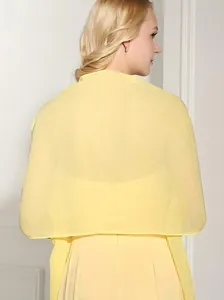 Detail view of lightweight yellow chiffon shawl, sheer summer fabric, elegant draped design.