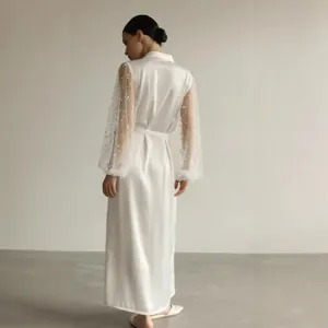Detailed view of white silk robe with sheer pearl mesh sleeves, elegant design showcase.