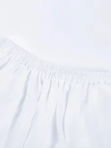 Close-up detail shot of the white elastic waistband and pleated fabric on a skirt.