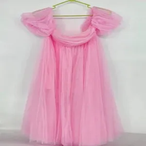 Pink off-shoulder mesh dress detail view, elegant tulle party evening gown and bridal features.
