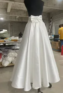 Strascico da sposa staccabile in raso bianco con elegante fiocco per servizi fotografici.