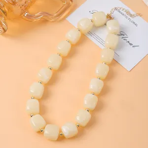 Primer plano detallado del elegante collar de cuentas cuadradas de resina beige para dama.