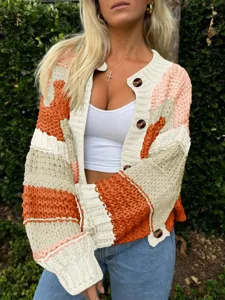 Détail du cardigan en tricot épais à blocs de couleur pour femmes avec manches longues et boutons.