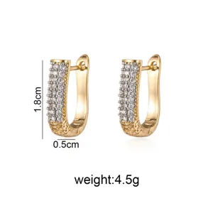 Detailed view of gold-tone geometric U-shaped rhinestone paved earrings, compact and elegant.