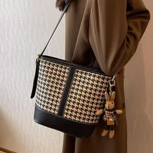Vue rapprochée du sac bandoulière pour femme en motif pied-de-poule avec détails en cuir.