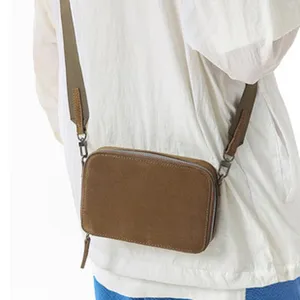 Sac bandoulière rétro marron pour femme avec fermeture éclair et sangle en toile pratique.