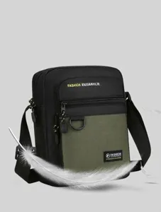 Close-up detail of the black and green men crossbody bag showing durable fabric and zipper.