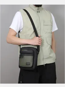 Detailed view of men's canvas crossbody bag showing two-tone design, strap and front pocket.