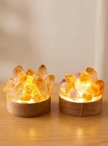 Détail de veilleuse en cristal, amas de cristaux bruts lumineux LED sur socle en bois.