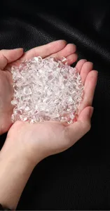 Primer plano de piedras curativas de cristal blanco claro en las manos, ideal para la meditacion.