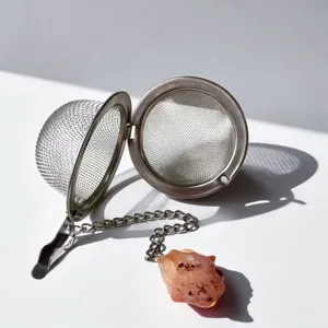 Stainless steel mesh tea infuser with chain and natural crystal stone pendant for loose tea.