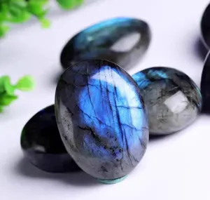 Gros plan détaillé de la pierre roulée en labradorite naturelle avec un effet de flash bleu.