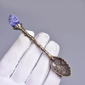 Antiker bronzener Löffel mit blauem Kristall und Blumenmuster für gemütliche Teestunden.