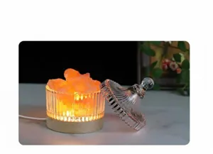 Vista detallada de la lámpara de sal de cristal con brillo ámbar, tarro y base de madera.