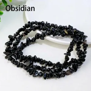 Vue de détail rapprochée de perles de copeaux de cristal d'obsidienne noire pour bijoux.