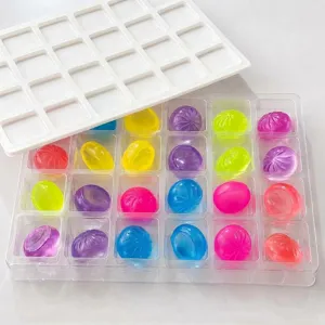 Gros plan de jouets anti-stress en cristal coloré dans une boîte plastique transparente.
