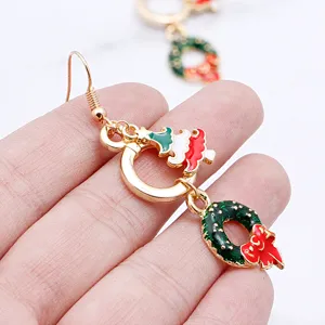 Detailed close-up view of Christmas tree and wreath drop earrings with colorful enamel.