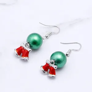 Close-up detail of Christmas bell earrings featuring green glitter beads and cute red metal bells.