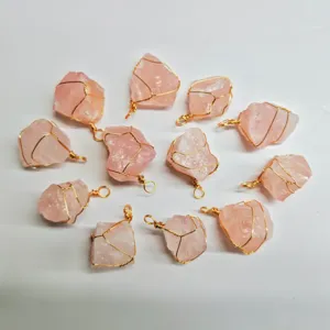 Detail view of handmade wire wrapped rough natural pink quartz crystal stone pendants.