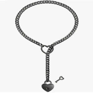 Gros plan sur le collier en chaîne en acier inoxydable noir avec cadenas en cœur.