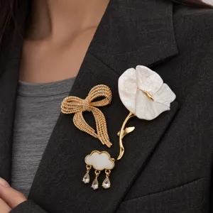 Close-up shot of elegant fashion bow, flower, and cloud crystal teardrop brooch pins.
