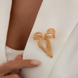 Gold textured bow brooch pin elegant lapel accessory for women fashion jewelry detail view