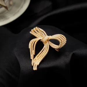 Gold bow brooch detail view, elegant metallic tassel metal pin for women fashion jewelry