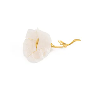 Detailed view of an elegant flower brooch with translucent white petals and gold stem.