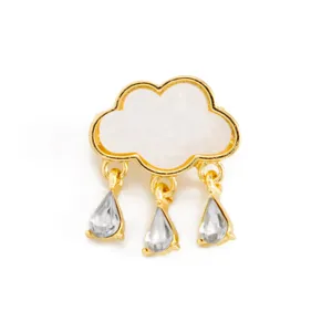 Close-up of a creative cloud brooch with hanging teardrop crystal tassels and gold trim.