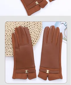 Detailed view of women winter brown faux leather touch screen gloves with chic metal buckle.