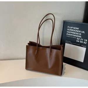Solid brown soft leather tote bag detail, featuring large capacity and elegant double shoulder straps.