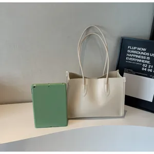 Detailed view of the elegant beige soft leather tote bag on modern display shelf.