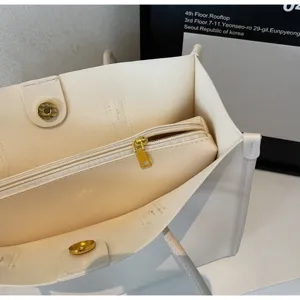Detailed view of cream white soft leather tote bag interior with inner zip pouch and hardware.