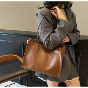 Detail view of the brown soft leather shoulder tote bag, large capacity and minimalist design.