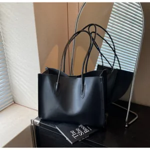 Detailed view of a stylish black soft leather tote bag, perfect for daily use and spacious design.