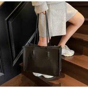 Detail view of the black soft leather tote bag showcasing texture and large capacity style.