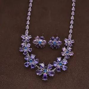 Detailed close-up view of the sparkling purple crystal flower necklace and matching earrings.