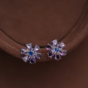 Detailed shot of exquisite purple crystal flower stud earrings with blue center stones for women.