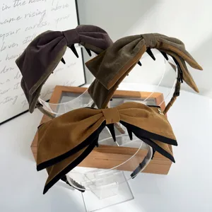 Vue détaillée de cerceaux de cheveux à grand nœud en velours vintage, design élégant pour femmes.