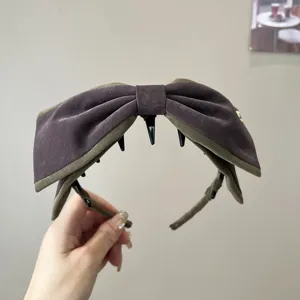 Détail du bandeau rétro à grand nœud 3D, présentant une texture en velours et des dents de peigne.