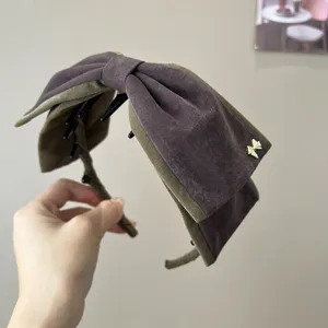 Serre-tête vintage en velours avec nœud et détail doré, élégant accessoire pour femme élégante.