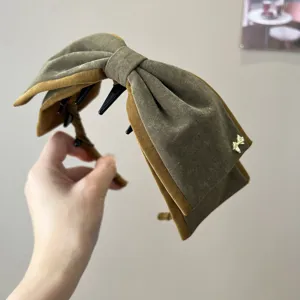 Gros plan du serre-tête nœud en velours rétro montrant une texture et couleur raffinées.