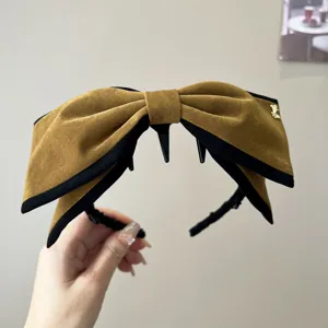 Vue détaillée du grand serre-tête nœud en velours rétro, design marron et noir élégant.
