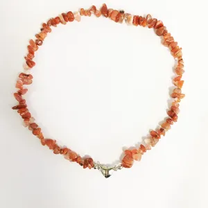 Dettaglio della collana di perle in pietra naturale frantumata con chiusura magnetica a cuore.