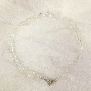 Primo piano dettagliato della collana di perle di cristallo bianco con chiusura magnetica.
