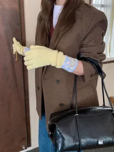 Détail de gants tricotés à pois avec manchette longue et texture douce et confortable.