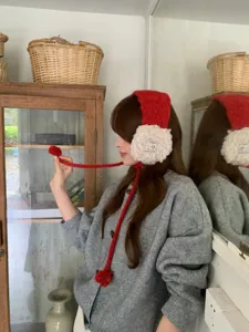 Accoglienti paraorecchie in lana d'agnello con pon pon pendenti, morbidi e caldi per l'inverno.