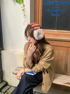 Detail view of winter fleece knit earmuffs with striped design, soft and warm for women.