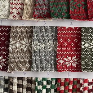 Close-up detail of Christmas jacquard knit fabric swatch with snowflake and geometric patterns.