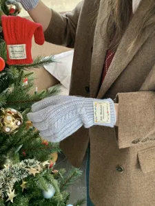 Guanti invernali in maglia trecce con etichetta, ideali per freddo intenso e decorazioni festive.